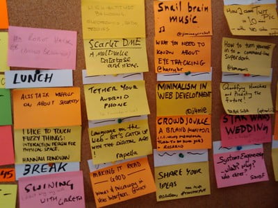 Photo by tristan_roddis on Flickr of a wall covered in post-it notes with speaking suggestions.