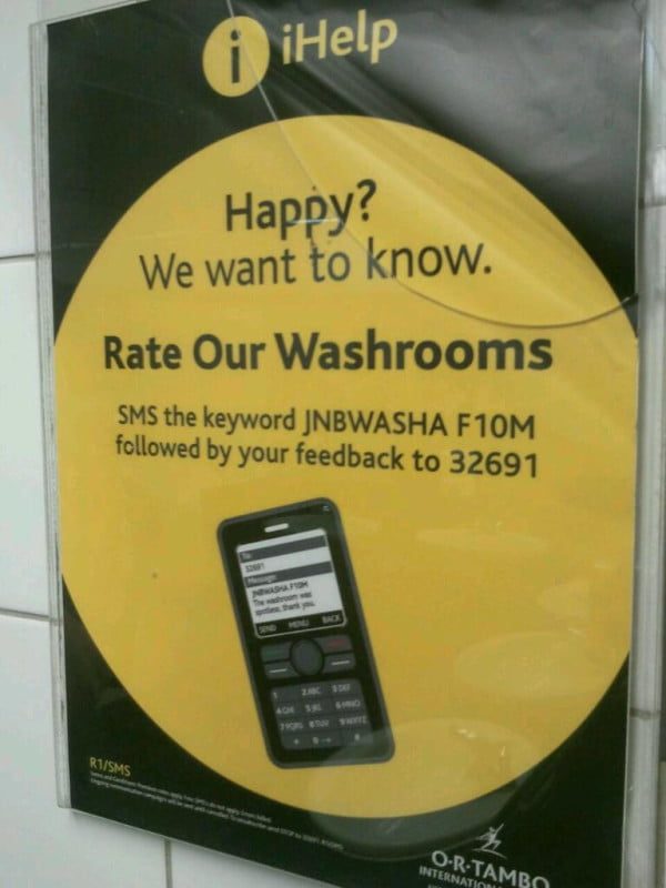 Advert encouraging people to SMS a shortcode to rate the cleanliness of a public bathroom.