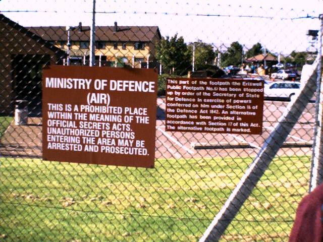 Sign on the fence explaining that the air base is protected.