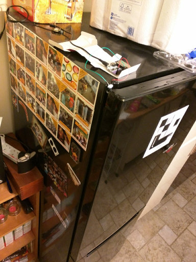 The internet fridge as viewed from above. Nestled among the dust on top is a micro-computer. Wires extend down to the door frame.