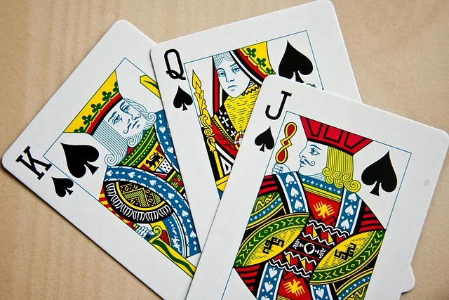 3 playing cards on a table.