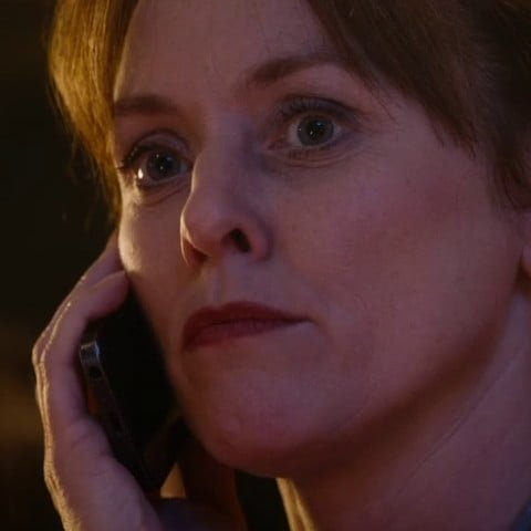 Moira holding phone.