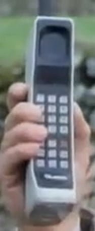 Tom Baker holding an old phone.