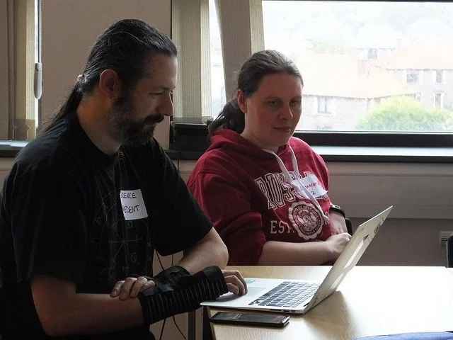 Terence and Liz at a laptop. Terence is wearing wrist braces.