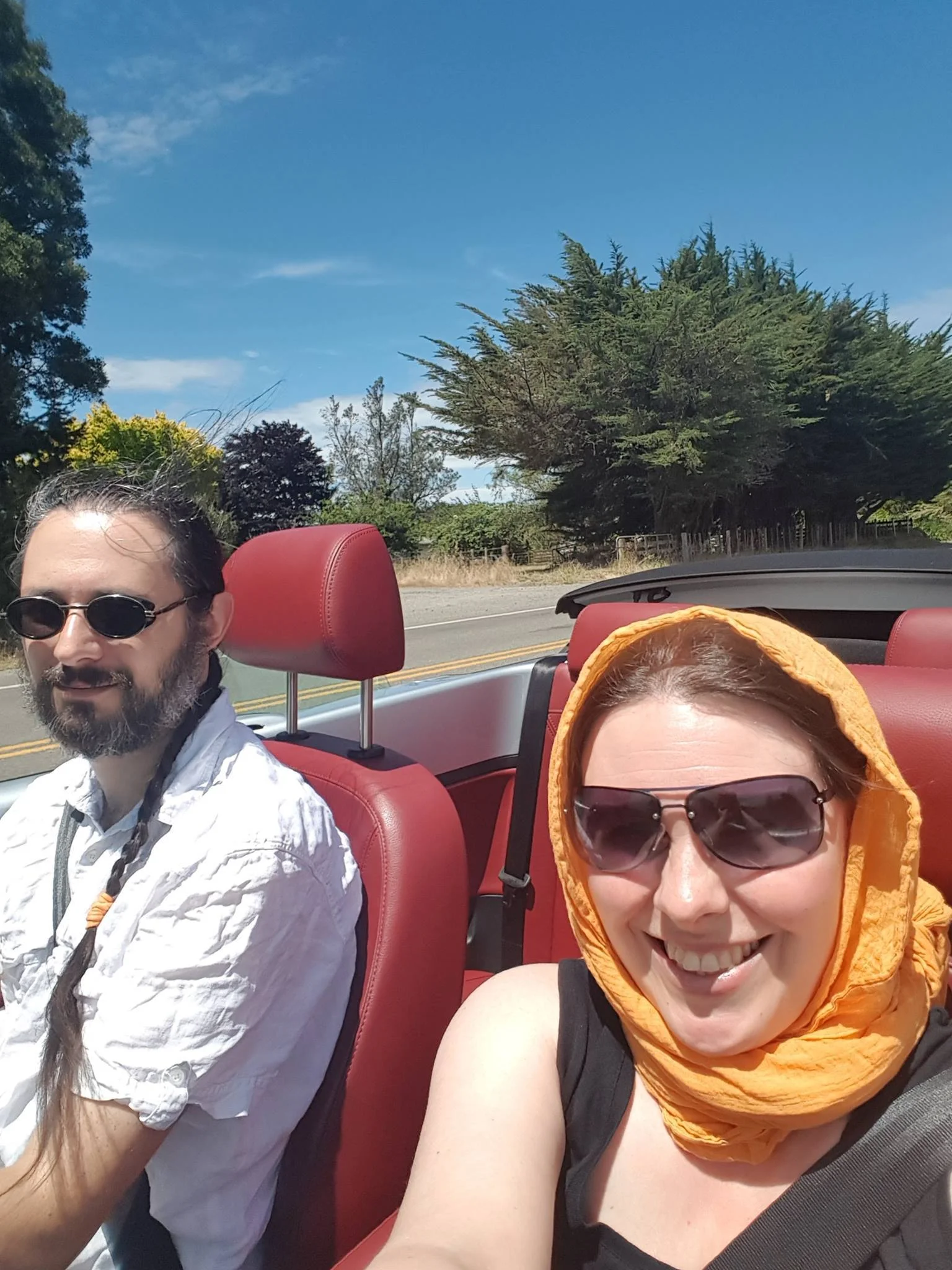 Terry and Liz in a convertable car, their hair flowing.