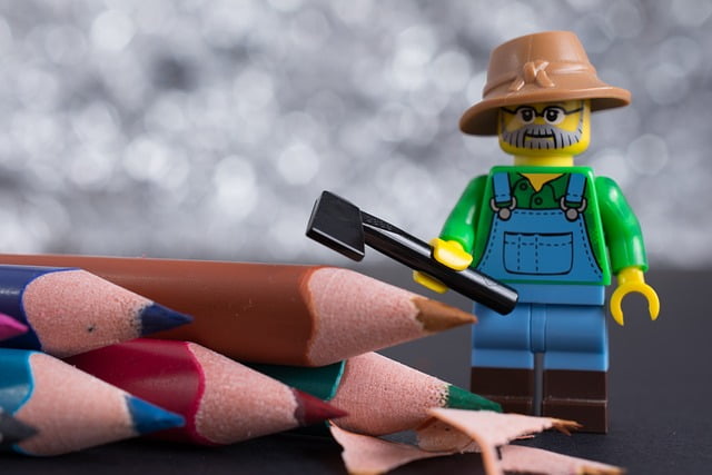 A little lego figure sharpening some coloured pencils using his little Lego axe.