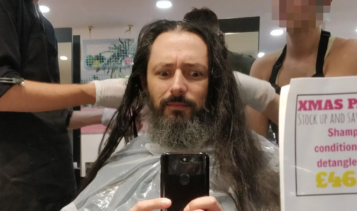 A long haired man with two hairdressers. It's me. And I look bemused.