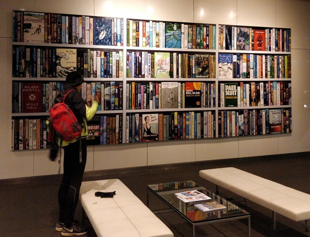 A wall spanning bookshelf with giant books.