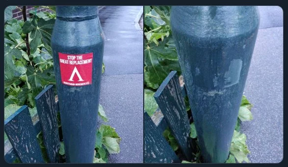 A "Stop the great replacement" sticker on a lamppost.