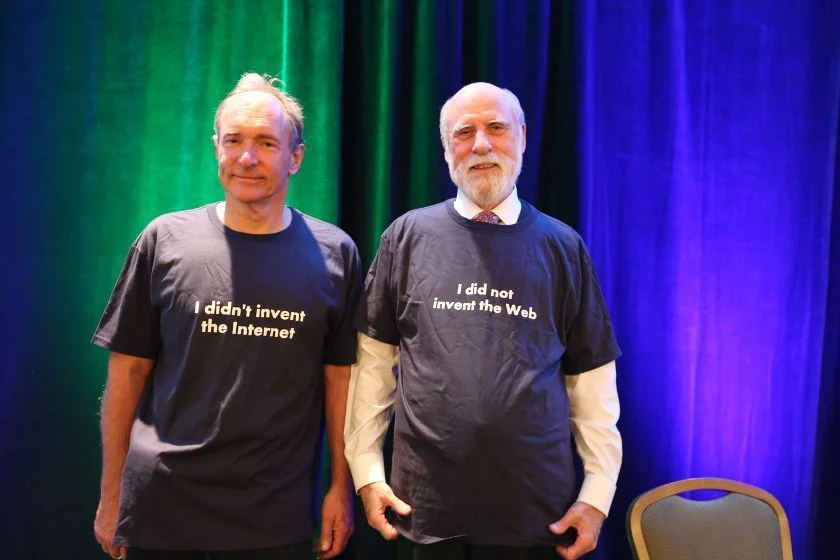 Photo of Tim Berners-Lee wearing a T-shirt which says "I didn't invent the Internet" and Vint Cerf wearing a T-shirt saying "I didn't invent the web".