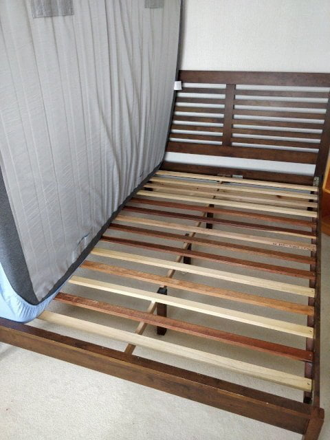 Mattress removed from bed exposing slats.