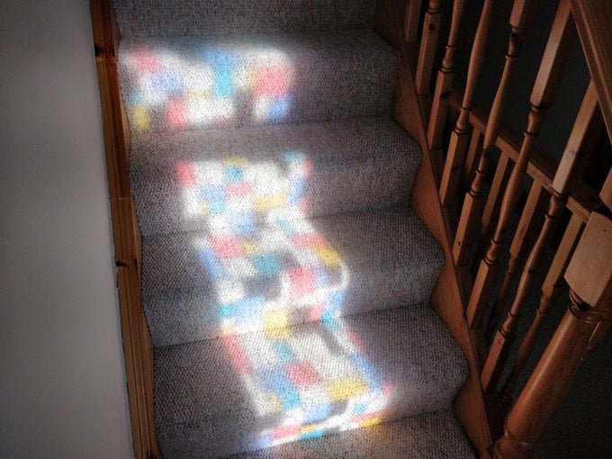 A beautiful pattern of coloured squares dances on the stairs.