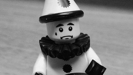 Black and white photo of a little Lego clown. He is sad.