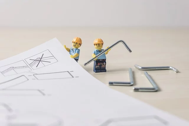 Two little Lego people try to build some flatpack furniture.