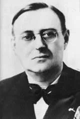 Black and white photo of a man wearing glasses and a bow tie.