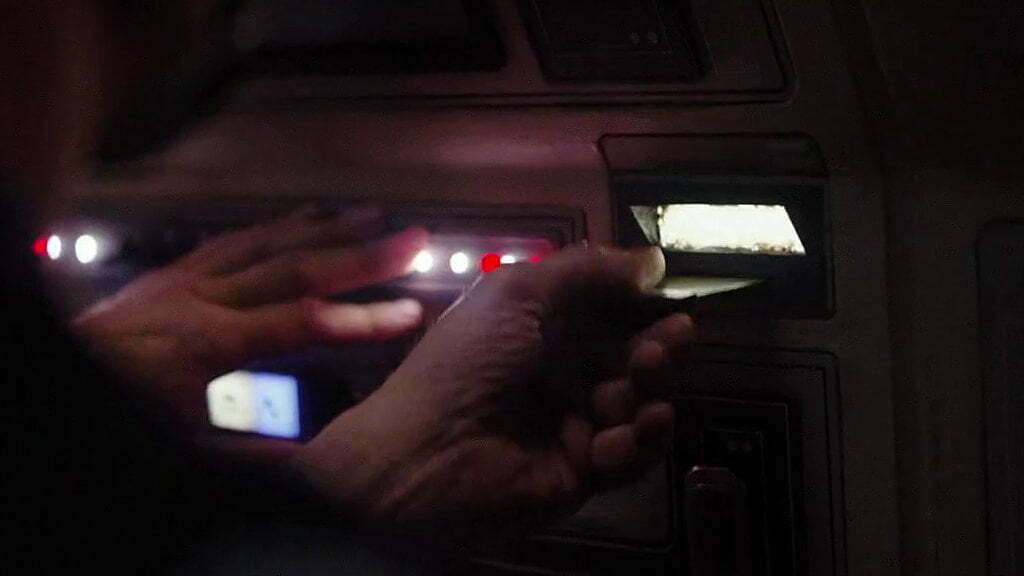 Still from Rogue One. A human hand pulls a  Data Tape from a computer.