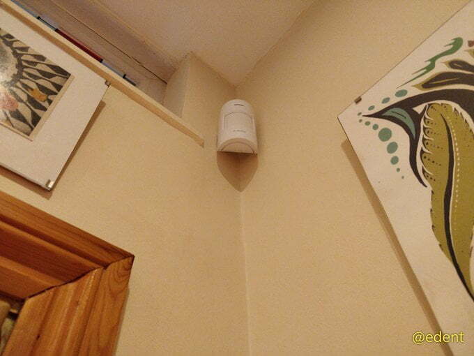 A motion sensor up in the corner between two walls.