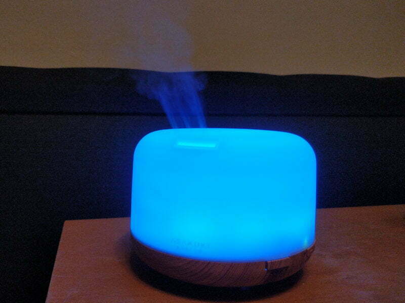 A diffuser lit up blue and bellowing smoke.