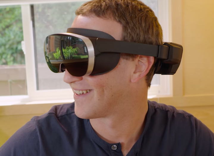Robot faced Mark Zuckerberg is wearing a VR headset - it digs painfully into his smiling cheeks.
