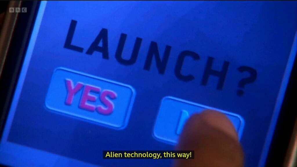 Still from Doctor Who. A PDA displays "Launch. Yes. No."