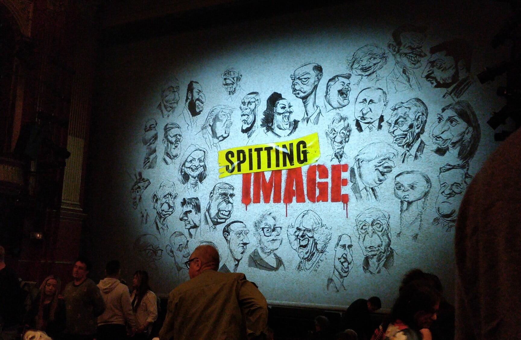 Photo of the safety curtain, showing caricatures of famous people.
