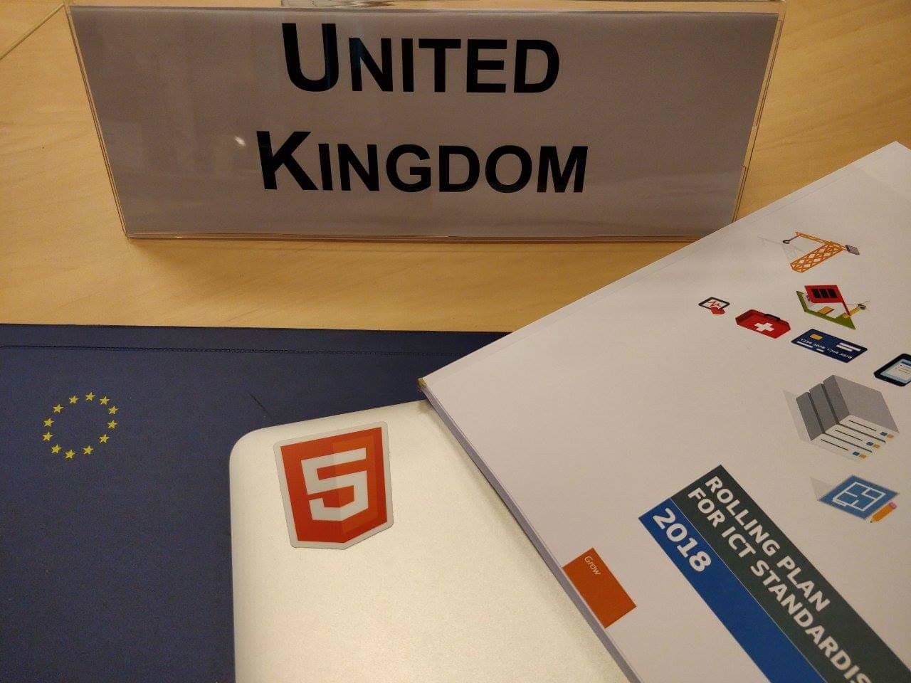 Photo of Terence's laptop in front of a UK sign at an EU meeting.