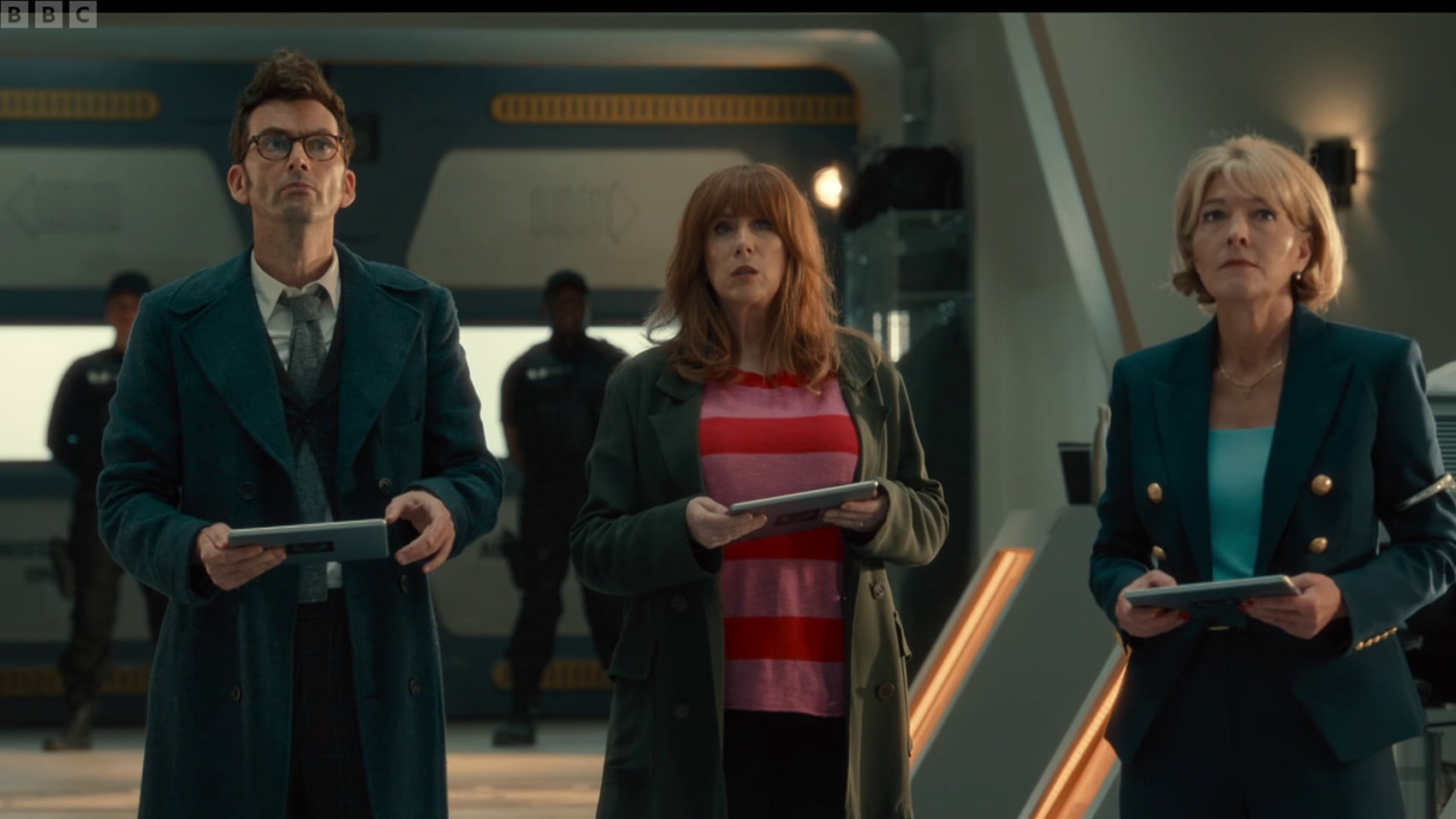 Doctor, Donna, and Kate holding identical tablets.