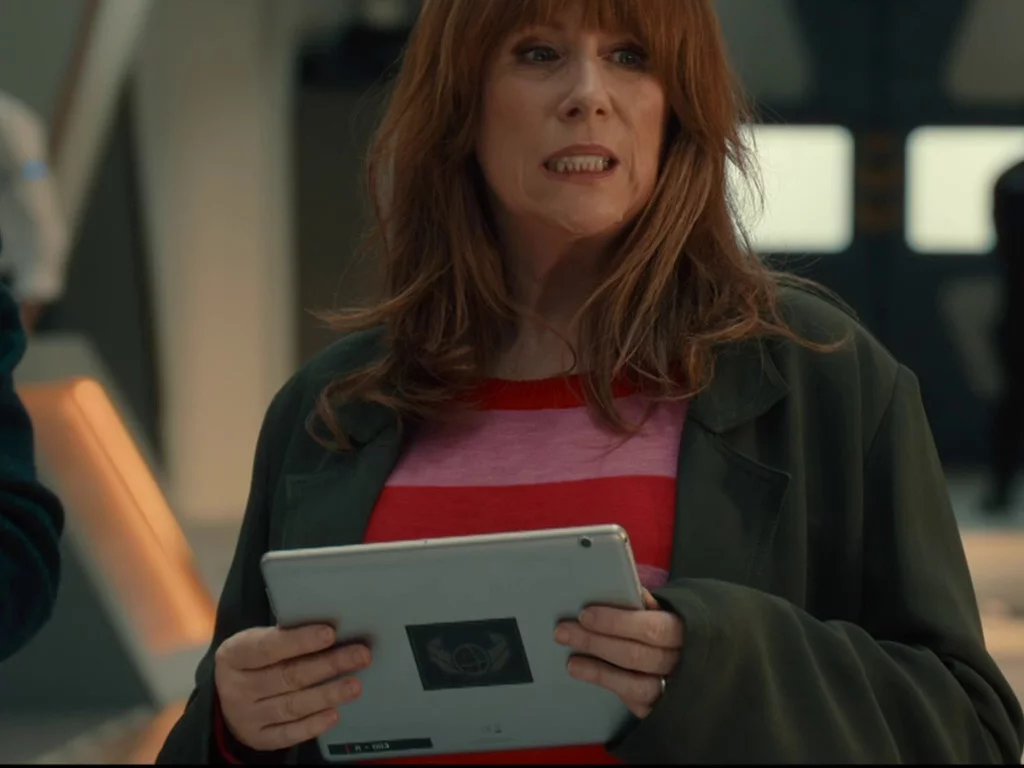 Detail of Donna holding a large white computer tablet.