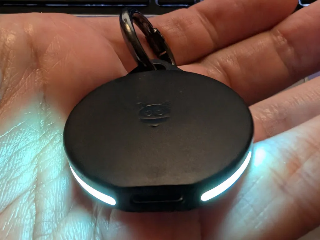 The disk has a USB-C socket at the bottom and flashing lights on the side.