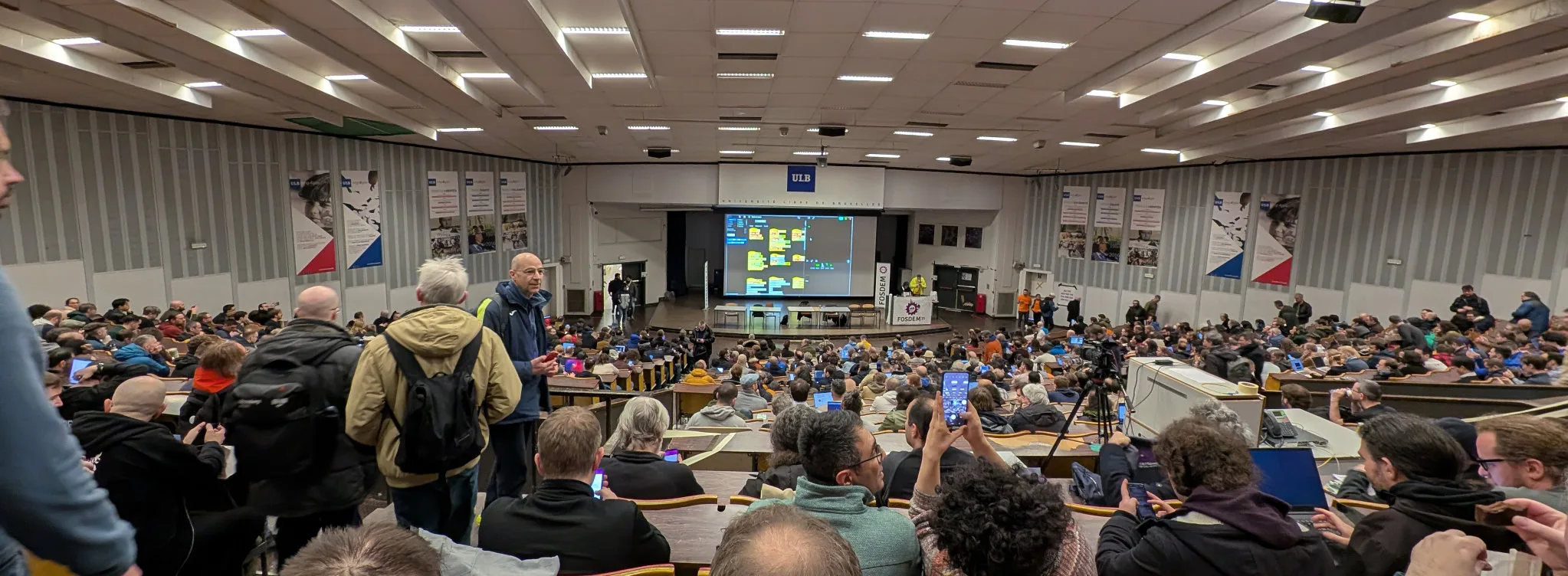 A lecture theatre full of people waiting for FOSDEM to start.