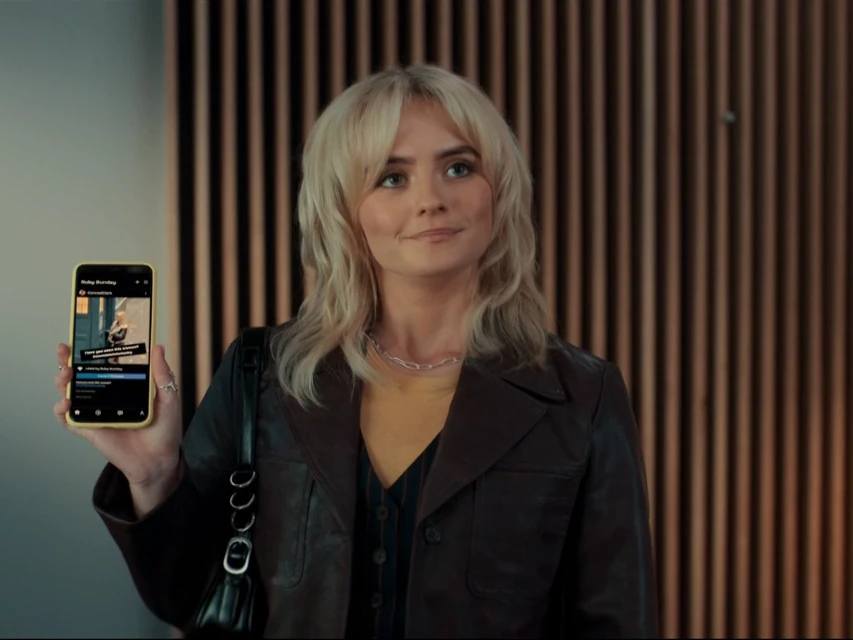 Woman holding a phone in a yellow case.