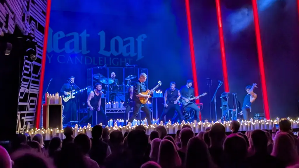 Four singers and a band surrounded by candles.