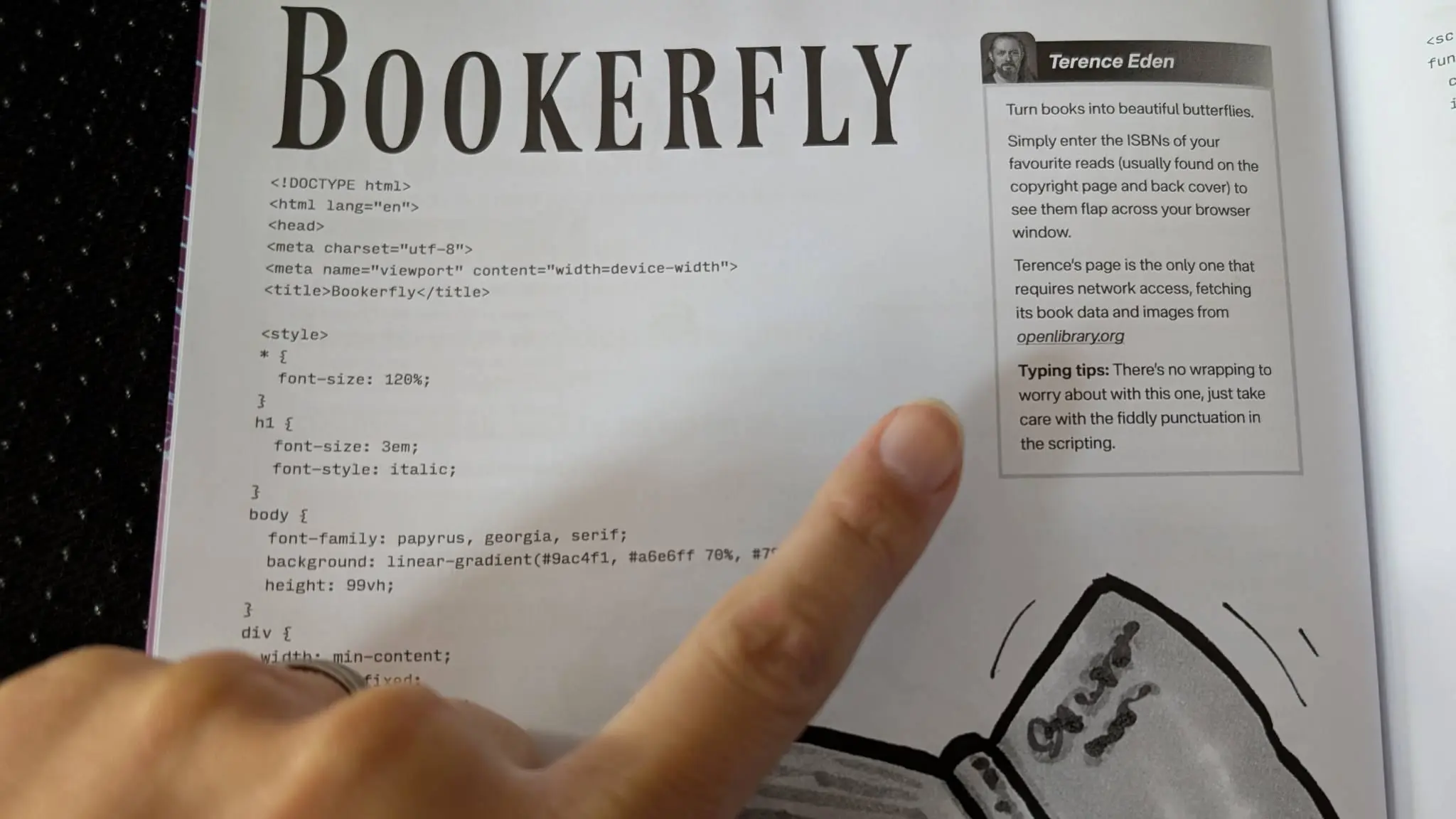 Page from a magazine. My finger is pointing to a block with my photo in it. HTML code is on the page.