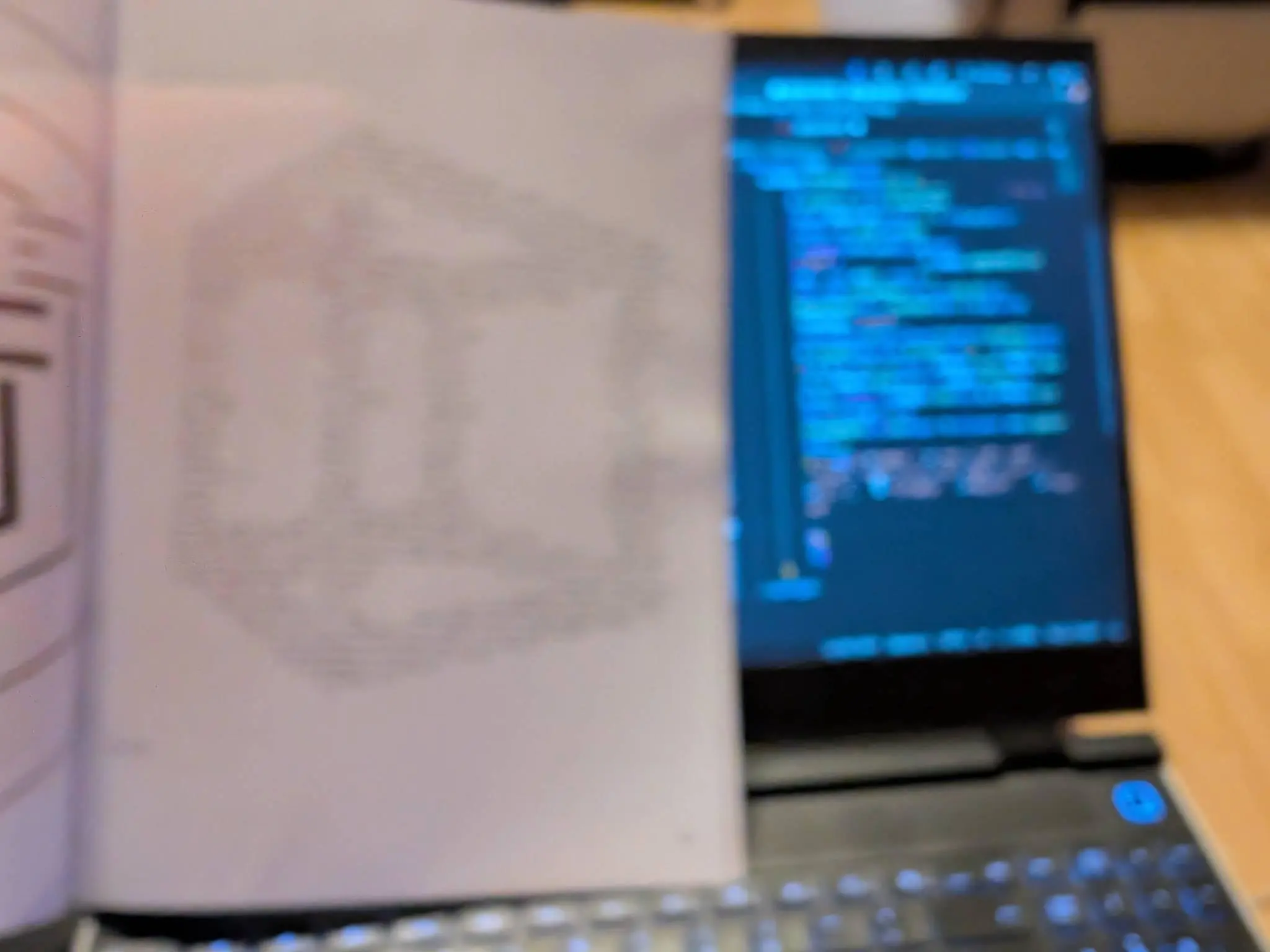 Out of focus photo of a magazine propped up on a laptop. The code editor is visible.