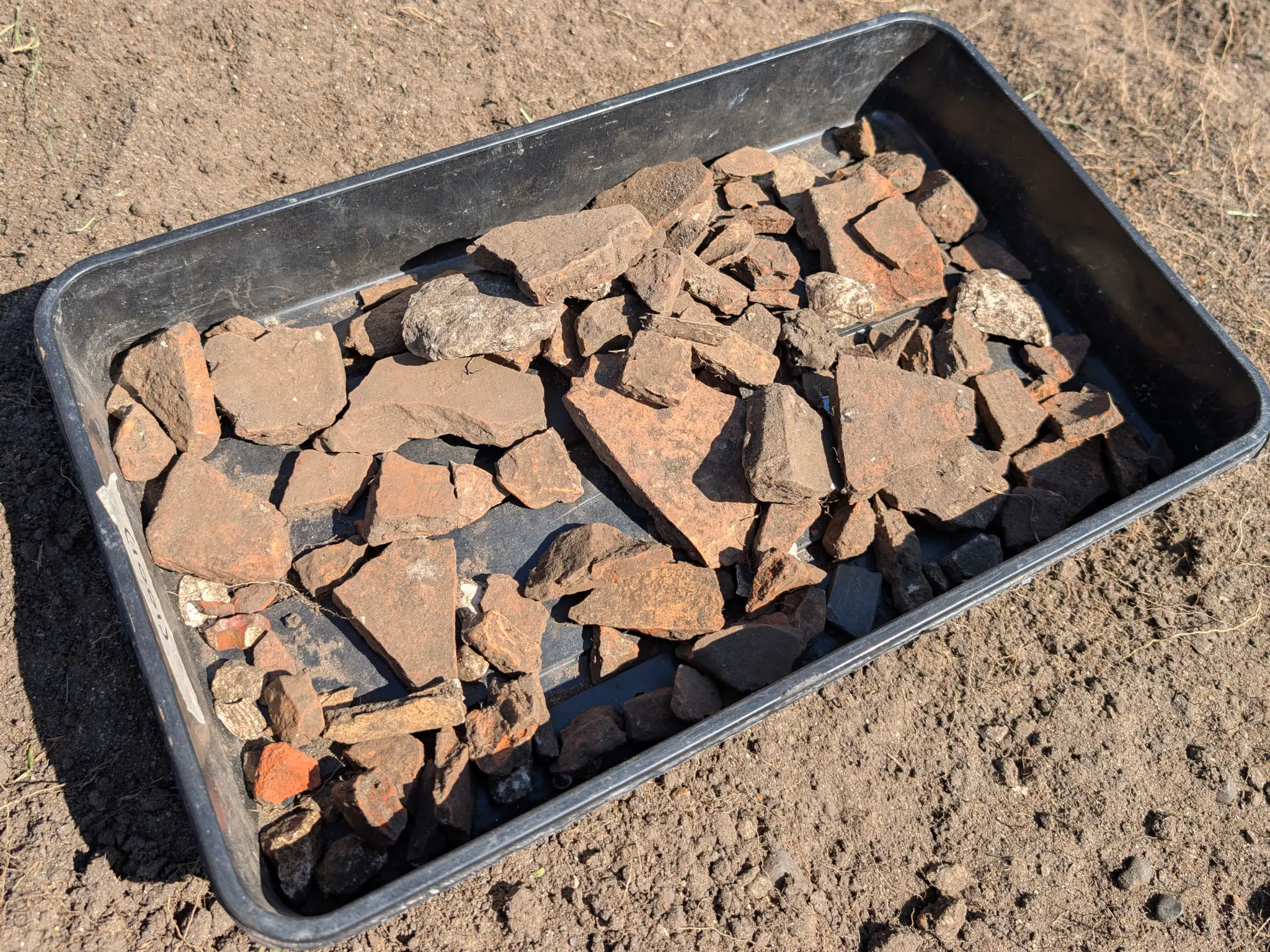 A shallow plastic tray filled with old tile.