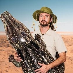Australian man holding an inflatable crocodile.