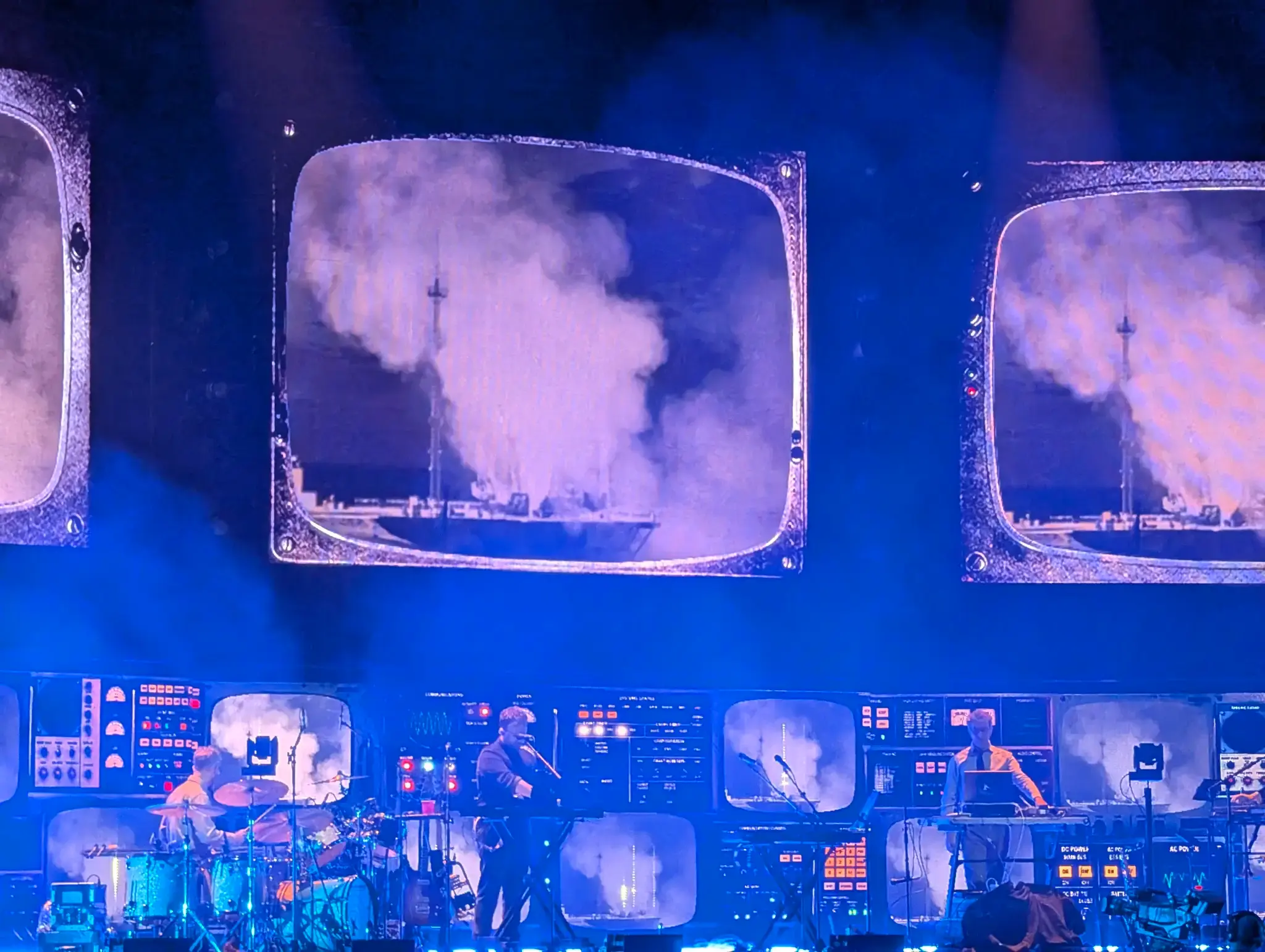 The band on stage with giant projections behind them.