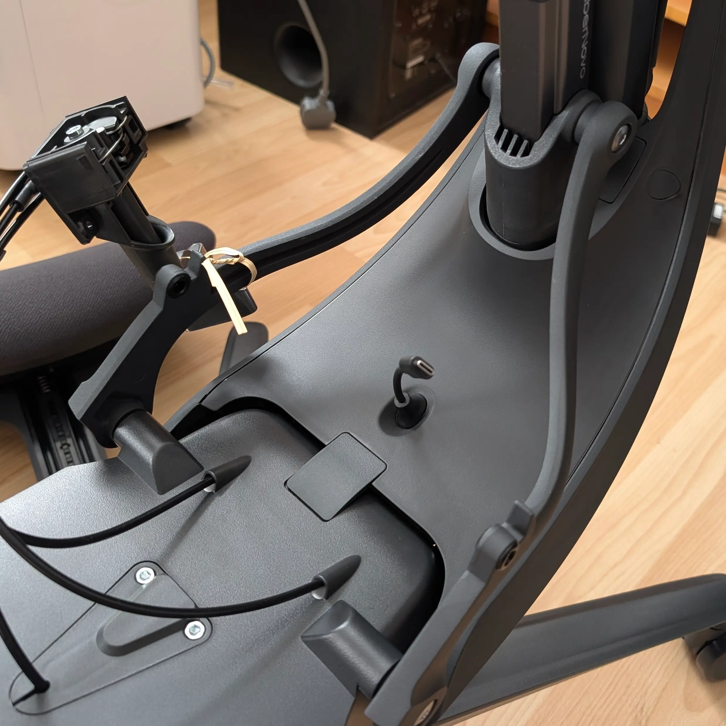 USB-C cable protruding from the chair - it looks like it goes RIGHT UP YOUR BUM!